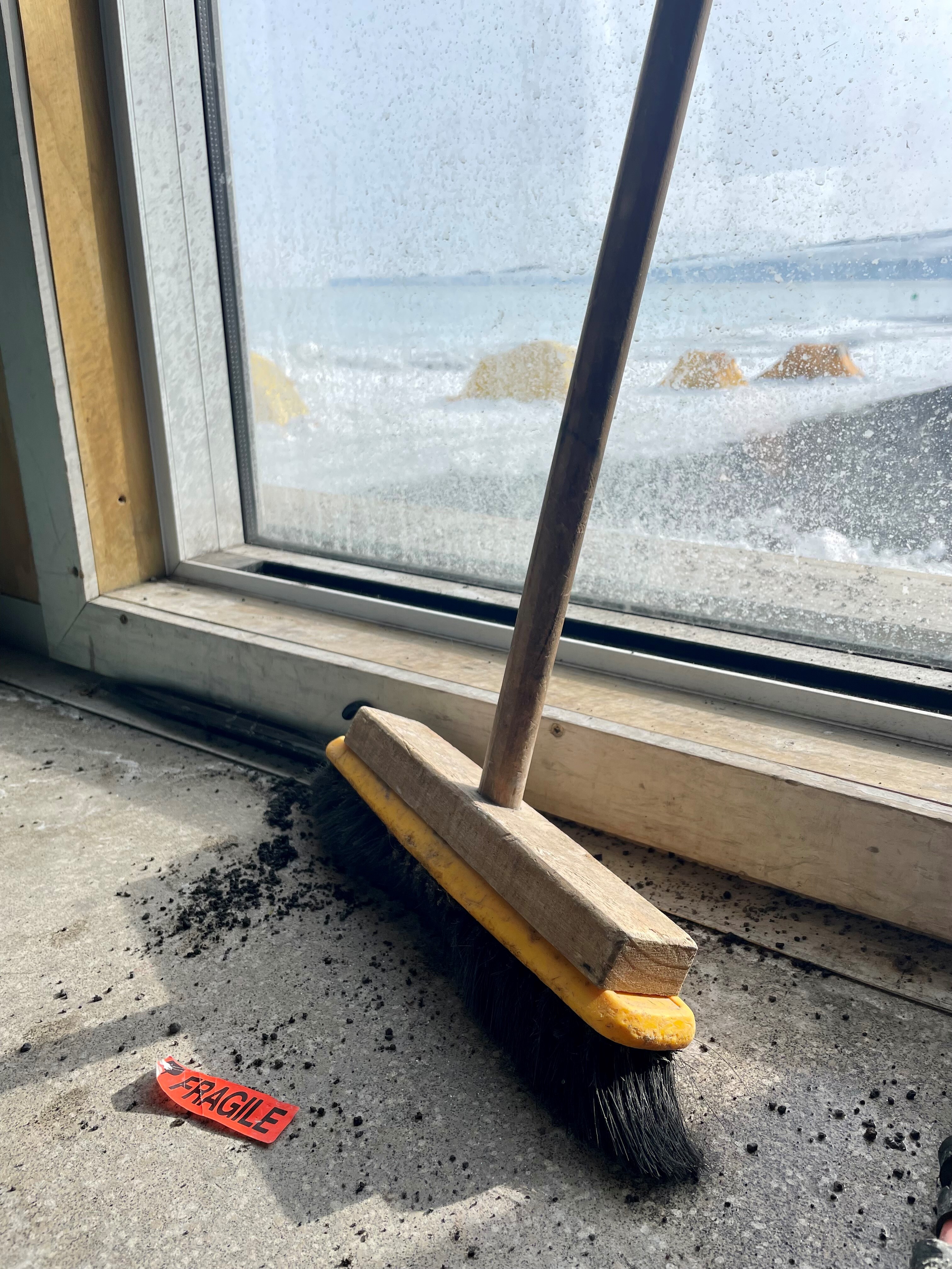 Broom and detached fragile label at West Beach camp container hut Cape Evans Photo Deborah Diaz
